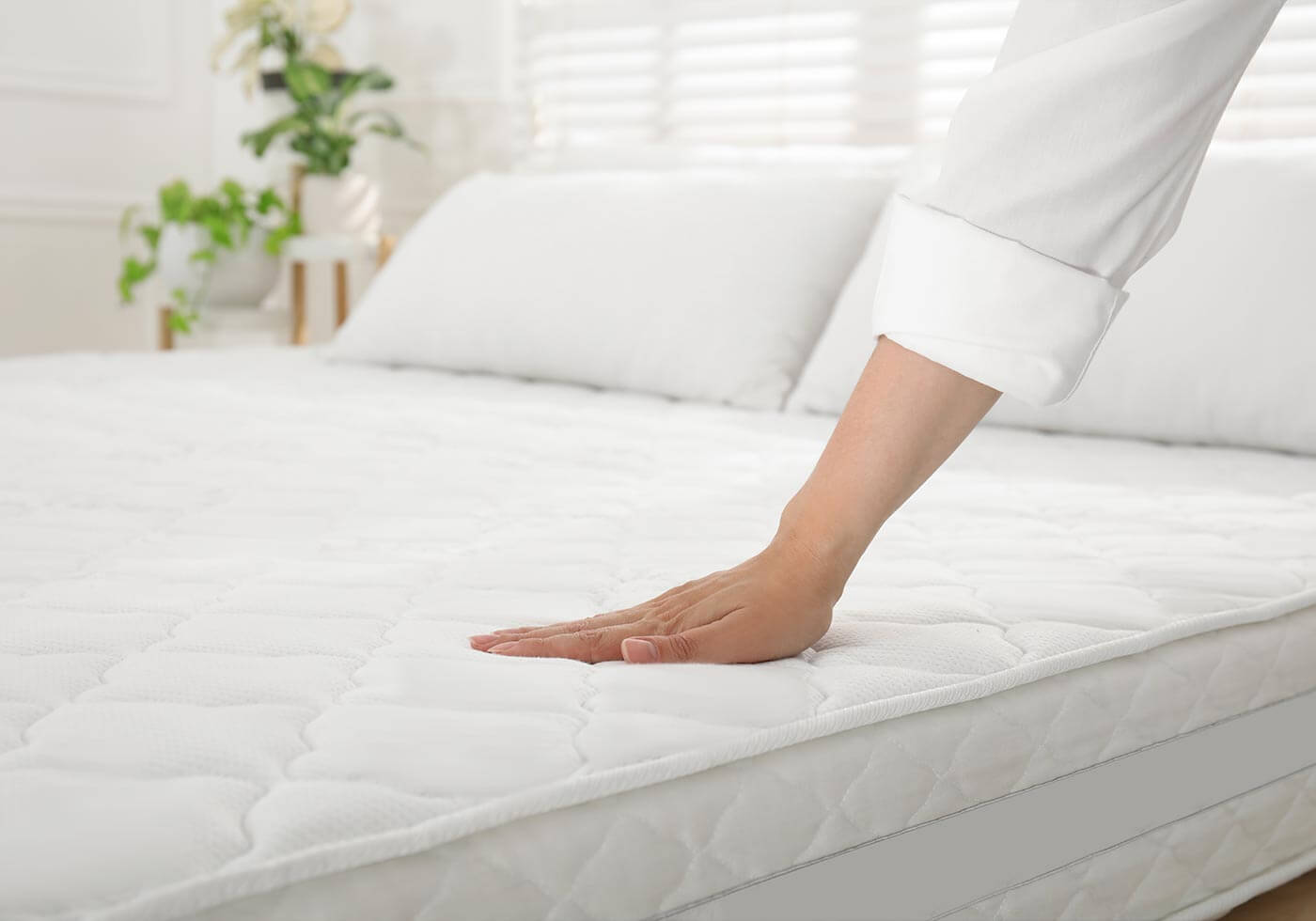 Hand pressing into a quilted mattress top